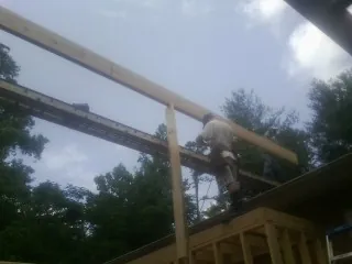 Carpenter setting a ridge beam over a new addition frame — Ice Dam Removal by Roofing Brothers in Rockwall