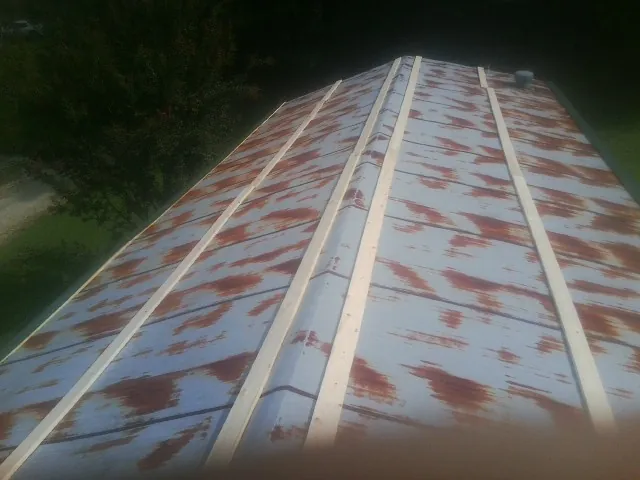 Rusted metal roof panels with new wood purlins before replacement — Storm Damage Roof Repair in Rockwall by Roofing Brothers