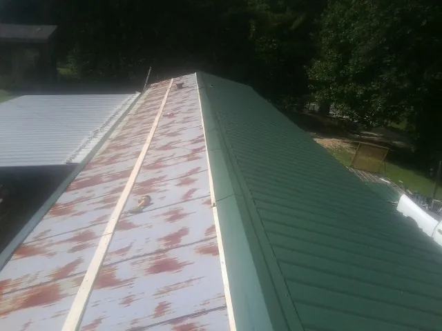 Old rusted panels beside newly installed green metal roofing — Wind Damage Roof Repair by Roofing Brothers in Rockwall