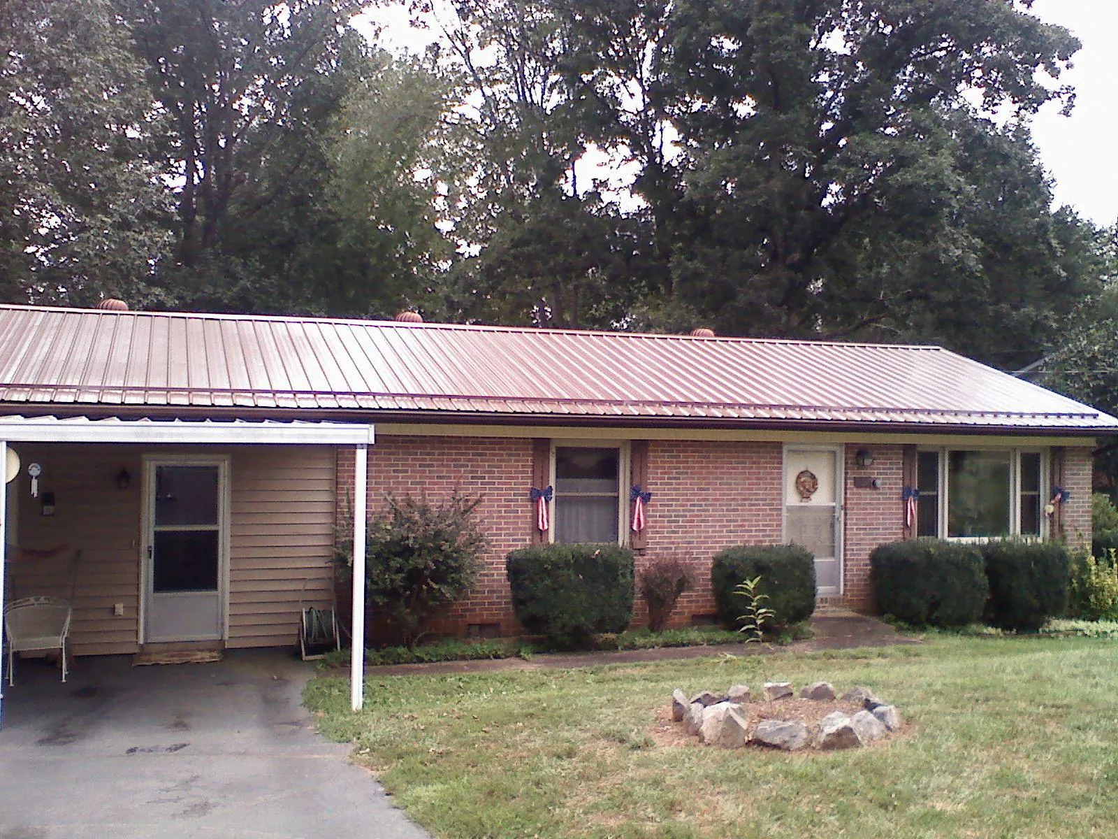 Bronze metal roof and carport on a brick ranch home — Roof Repair work by our crew in Rockwall
