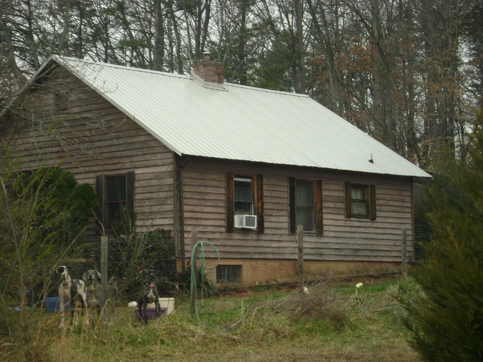 White metal roof on an old wood sided farmhouse, from a Metal Roof Installation job in Rockwall